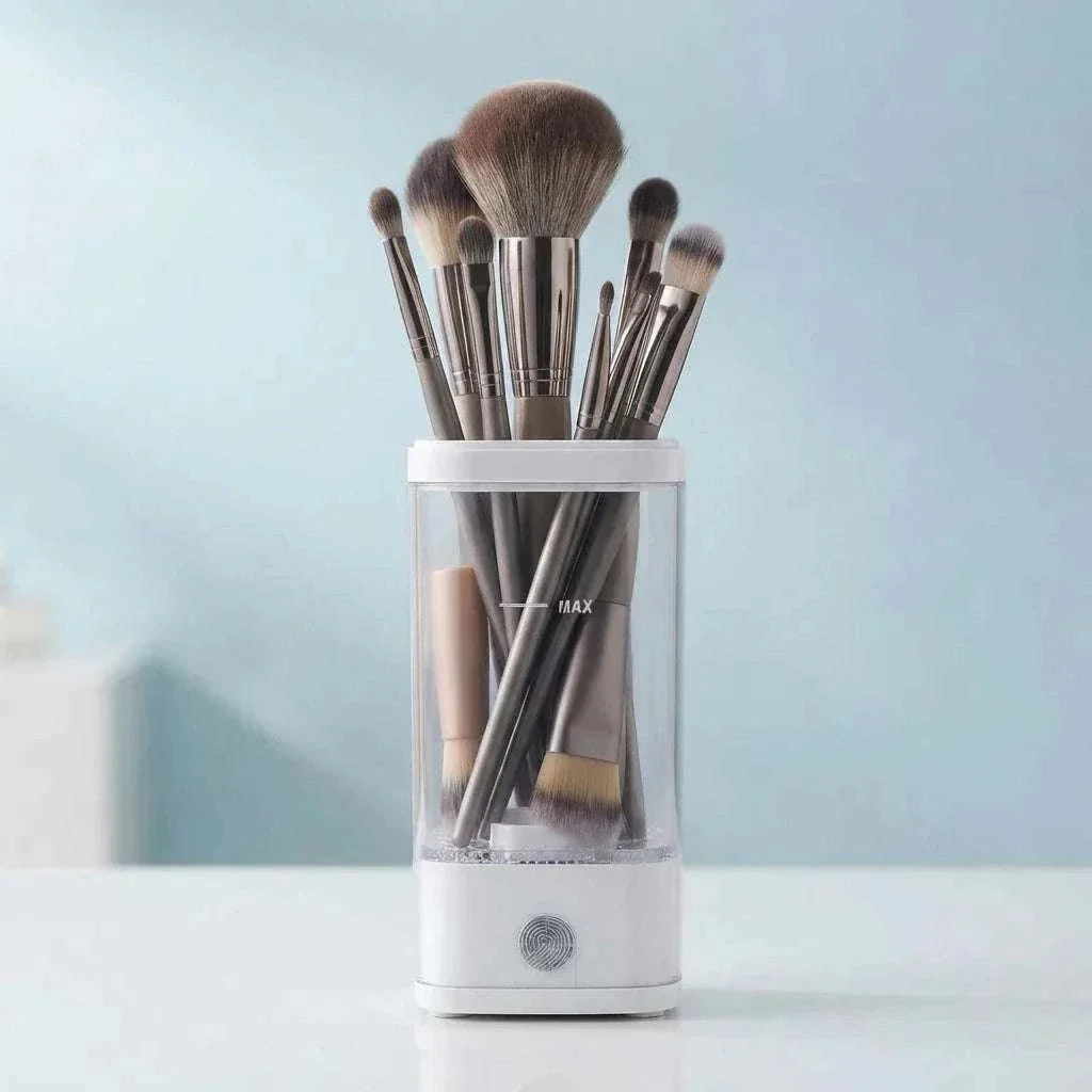 CleanLuxe Automatic Makeup Brush Cleaner with transparent body and white base holding multiple makeup brushes with soft bristles of various sizes